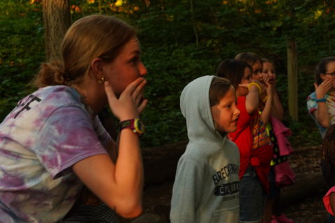 Riley Garmatter and campers sing at campfire