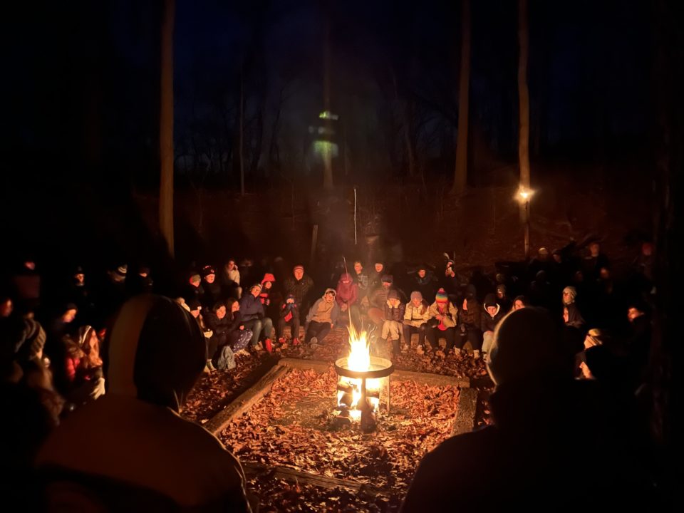 People sitting around the campfire at night