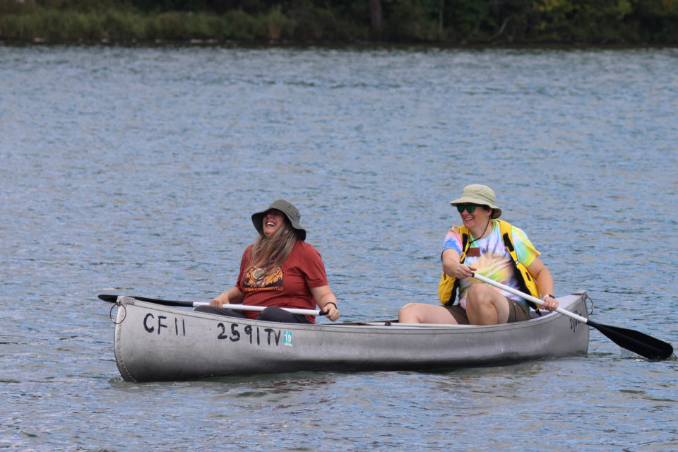 two people floating on canoe on lake